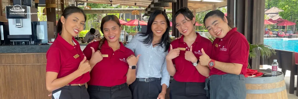 Young hospitality professional stepping into a luxury hotel lobby abroad, beginning their career journey with RMC Asia